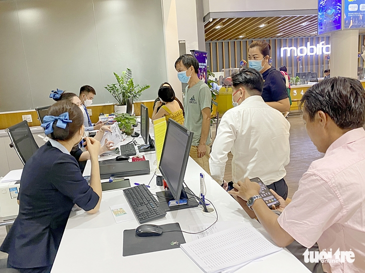Người dân chờ đợi để cập nhật thông tin thuê bao di động tại một cửa hàng MobiFone ở quận 1, TP.HCM sáng 16-3 - Ảnh: TỰ TRUNG